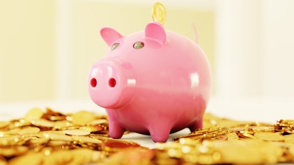 Piggybank sitting on top of gold coins