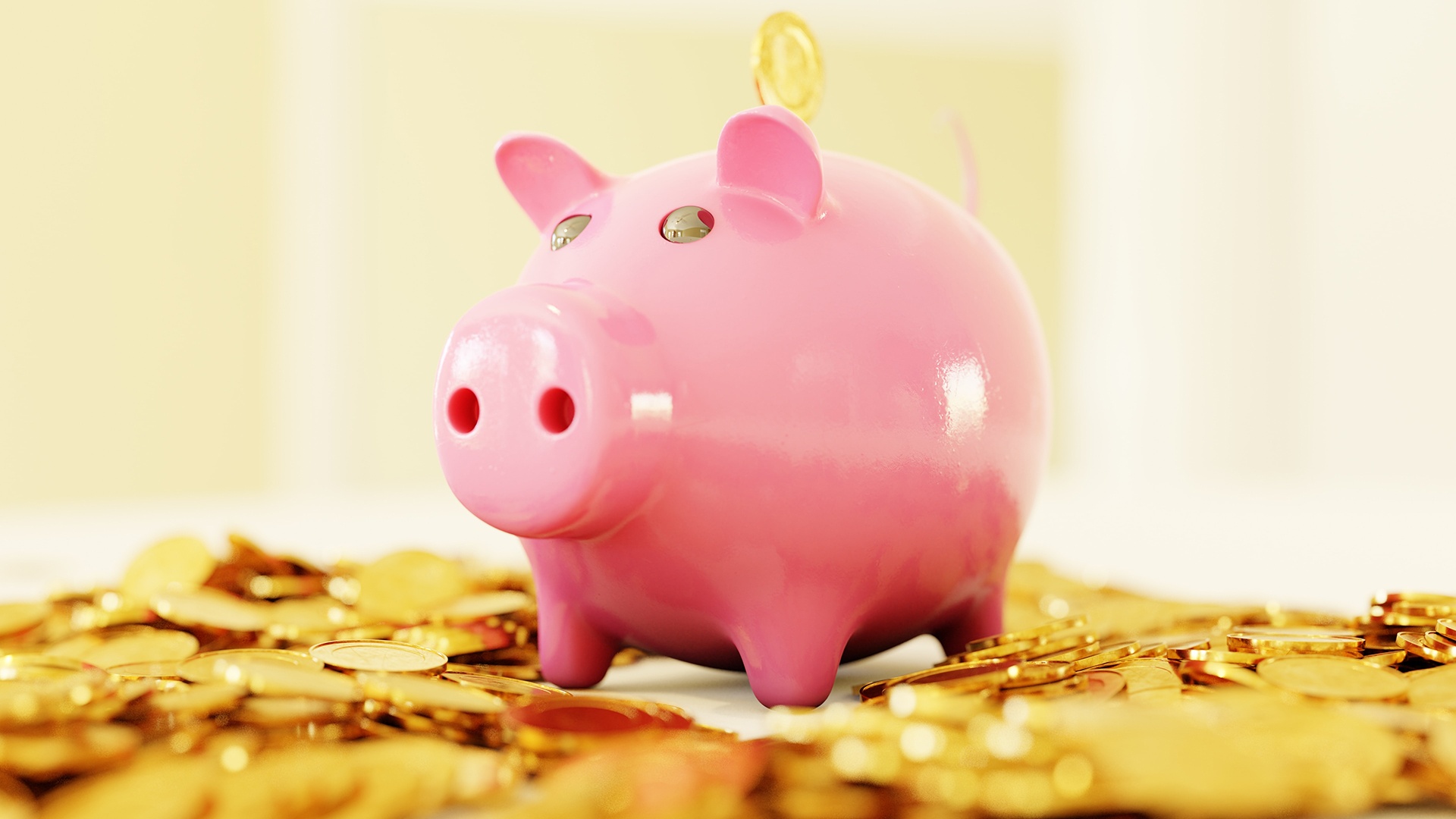 Piggybank sitting on top of gold coins