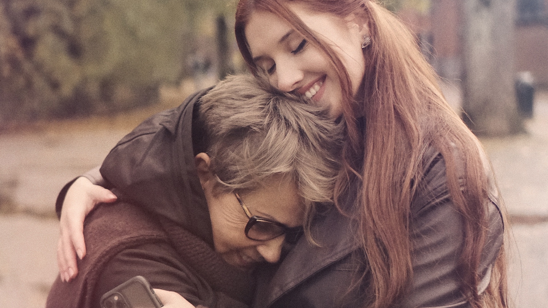 two women hugging on city street