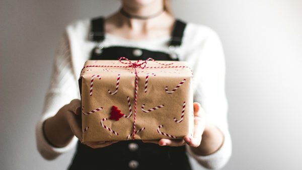 Person presenting a wrapped gift