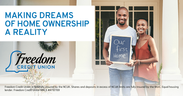 Couple holding a sign that says our first home