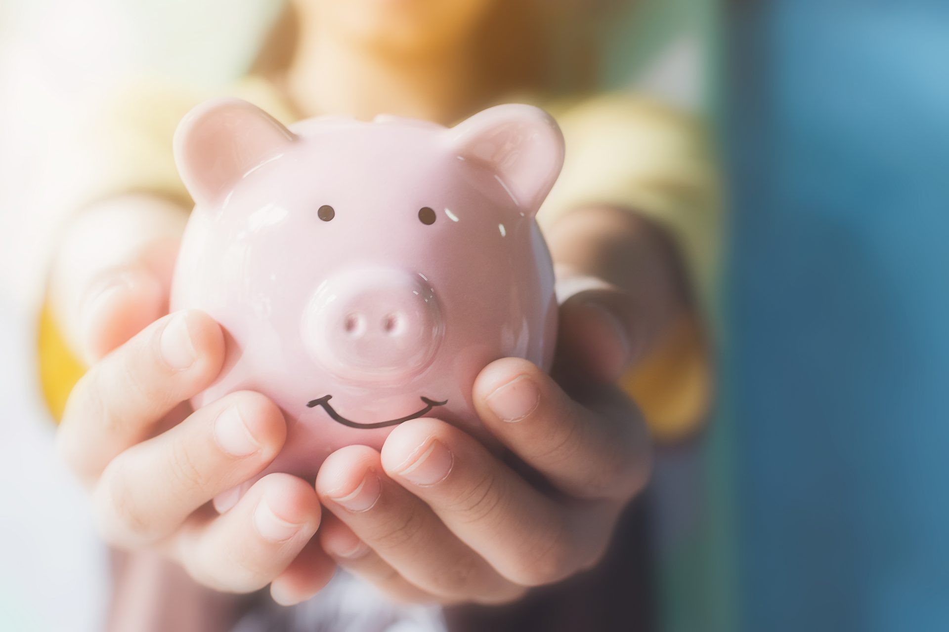 child holding pink piggy bank