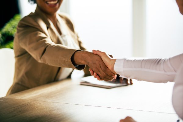people shaking hands over a desk