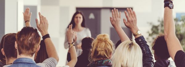Students raising hands in classroom