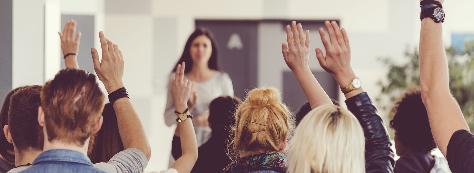 Students raising hands in classroom