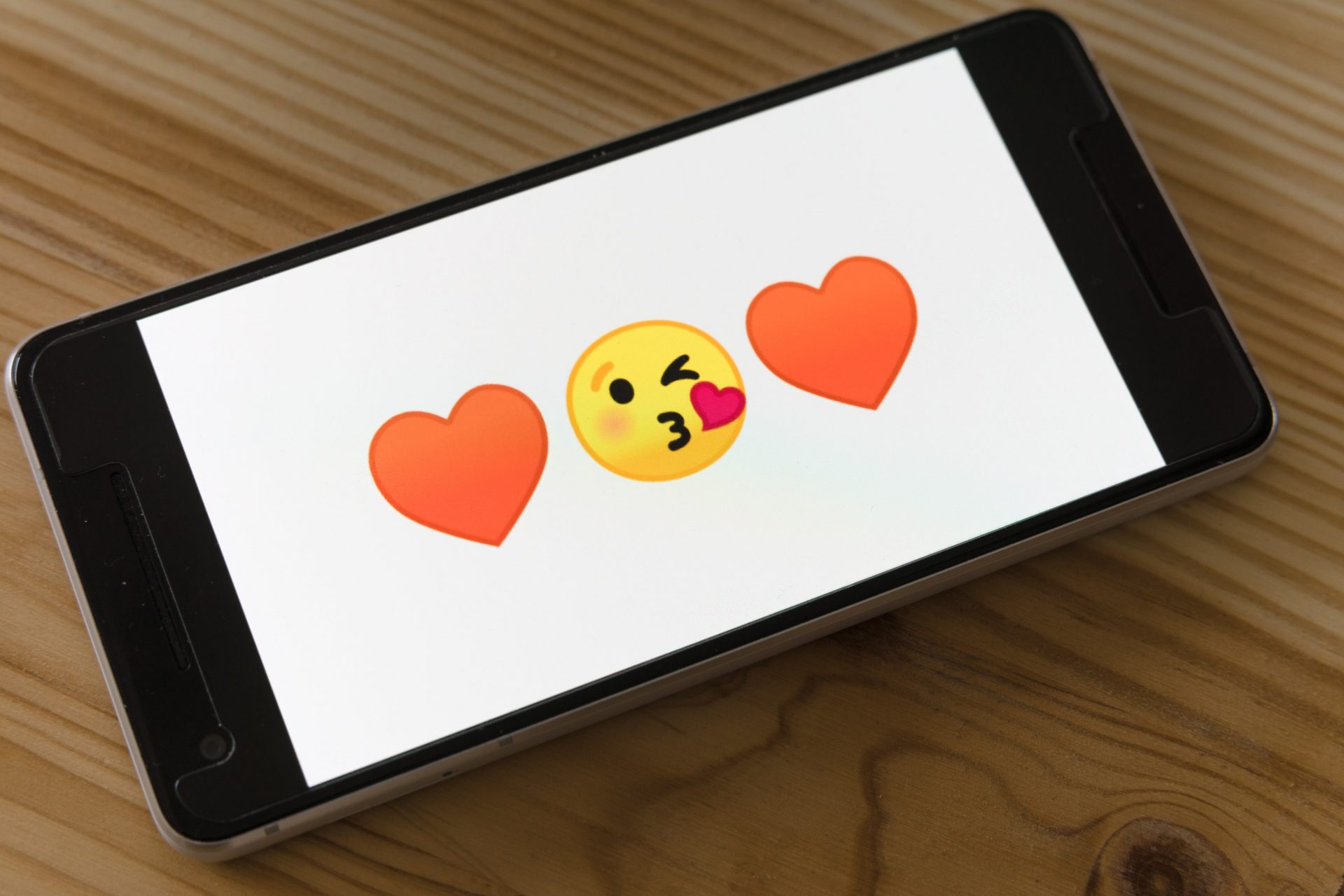 phone with kissing emoji and hearts